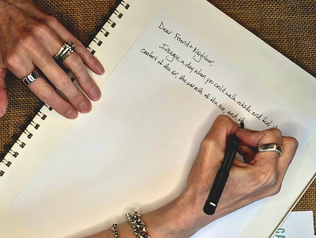 Hands writing a handwritten letter in a spiral notebook — why I write to strangers 